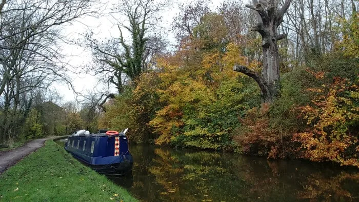 Autumnal view of Leeds and Liverpool canal with barge near Bingley