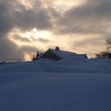 House Covered in Snow with Morning Sunshine