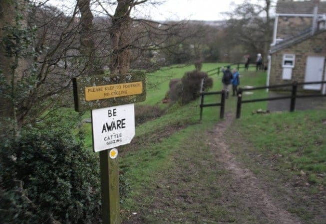 Walkers passing by a house overlooking the River Aire in Bingley