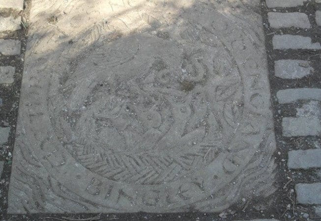 Plaque on riverside footpath with text: "The Throstles Nest of Old England Bingley"